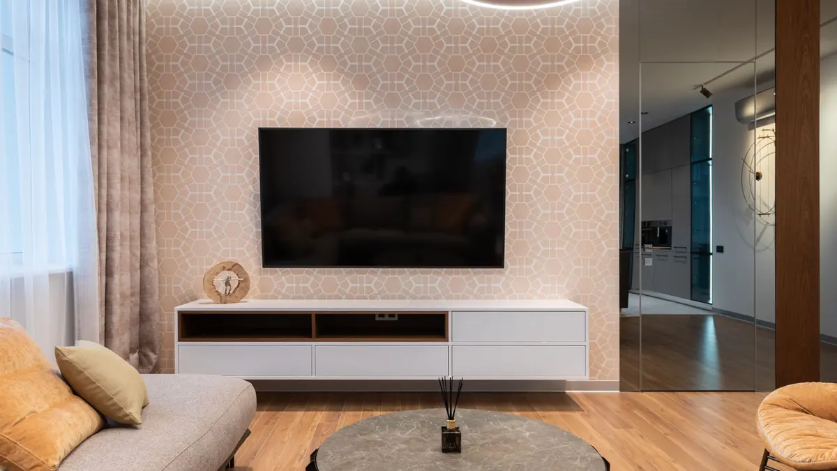 Large flat screen television mounted on a modern living room wall above a cabinet